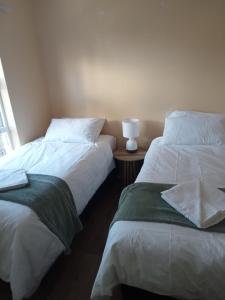 two beds sitting next to each other in a room at Blouberg Holiday Haven in Cape Town