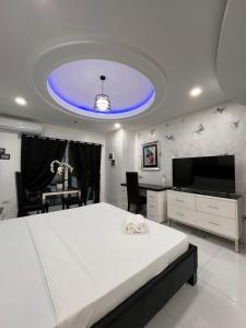 Μια τηλεόραση ή/και κέντρο ψυχαγωγίας στο Sheryll Escapes - Kandi White Studio with balcony Housekeeping & Wi-Fi!