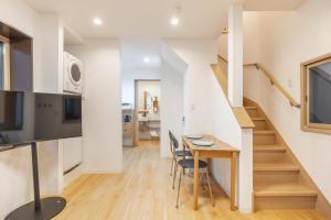une cuisine et une salle à manger avec un escalier, une table et des chaises dans l'établissement TaroTime Shinjuku Serene Japanese Cottage, à Tokyo