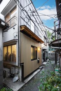Elle offre une vue sur l'extérieur d'une maison dotée d'une façade en bois. dans l'établissement TaroTime Shinjuku Serene Japanese Cottage, à Tokyo