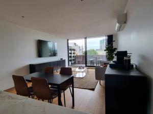 a living room with a table and chairs and a large window at It's Melbourne - by the Beach! in Melbourne