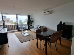 a living room with a table and chairs and a couch at It's Melbourne - by the Beach! in Melbourne