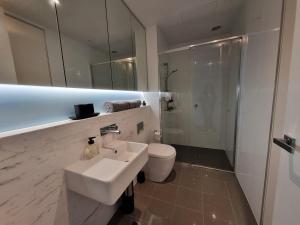 a bathroom with a sink and a toilet and a mirror at It's Melbourne - by the Beach! in Melbourne +9 photos
