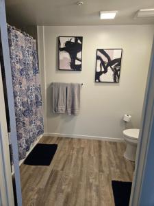 een badkamer met een toilet en drie foto's aan de muur bij Downtown 2 bedroom apartment in Los Angeles