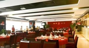 a restaurant with tables and chairs and people in the background at Orient Sunseed Hotel Airport Branch in Minzhu +71 photos