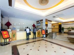 un vestíbulo con dos personas parados en un mostrador en Ming Yang Hotel, en Haikou