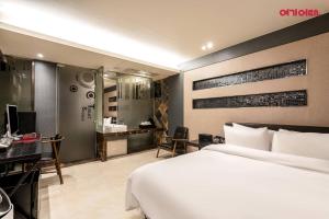 ソウルにある힙호텔のベッドと机とパソコンが備わったホテルの部屋