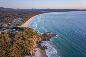 une vue aérienne d'une plage et de l'océan dans l'établissement 102 Coraki Drive Pambula Beach, à Pambula Beach 1 autre photo