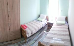 two twin beds in a room with a door at Apartments Sadina in Skradin