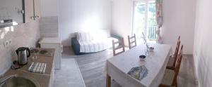 a kitchen with a table and a living room at Apartments Sadina in Skradin