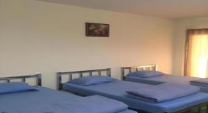 a room with three beds with blue pillows at V.R.Mansion Hotel in Phatthalung