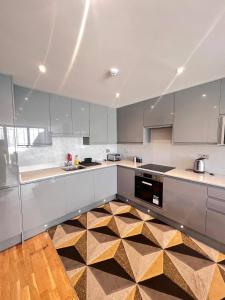 eine Küche mit weißen Schränken und einem karierten Boden in der Unterkunft Finchley Unique home in Finchley