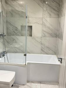 ein weißes Badezimmer mit Badewanne und Toilette in der Unterkunft Finchley Unique home in Finchley