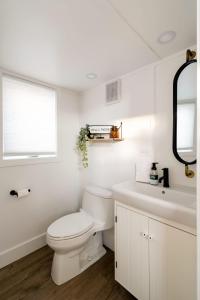 a white bathroom with a toilet and a sink at Stay Portland - The Tiny Farmhouse on Alberta in Portland