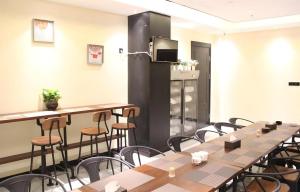 Cette chambre dispose de tables, de chaises et d'un réfrigérateur. dans l'établissement Xana Lite Korla Xiangli Avenue Food Street, à Korla