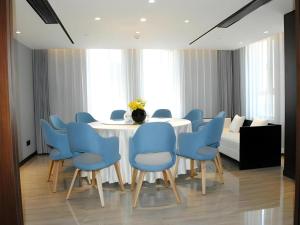 un comedor con una mesa blanca y sillas azules en Jinjiang Inn Select Changchun Yuanda Street, en Changchún