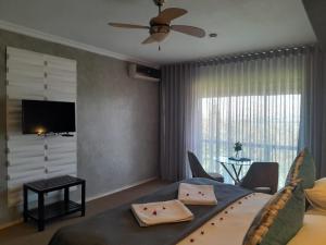 a hotel room with a bed and a tv and a living room at Bush Baby View Lodge in Hartbeespoort