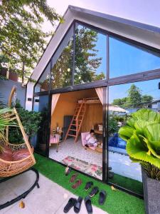 una casa con un bambino seduto su un'amaca accanto a una piscina di Private Villa with Pool - Intimate Celebration a Manila Altre 87 foto