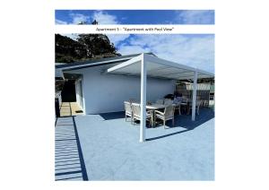 a pavilion with a table and chairs under a canopy at Stay n Play n Russell in Russell