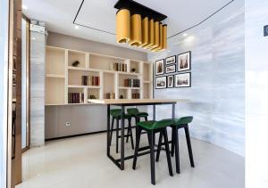 EnpingにあるCity Comfort Inn Jiangmen Enping Bus Terminalのダイニングルーム(テーブル、緑のスツール付)