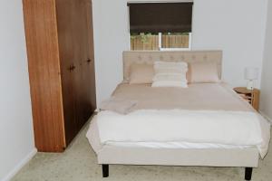 a bedroom with a large bed with white sheets and pillows at Carthage Terrace in Tamworth