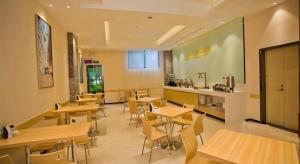 a restaurant with wooden tables and chairs and a kitchen at City Comfort Inn Deyang Wenmiao Square Gymnasium in Deyang