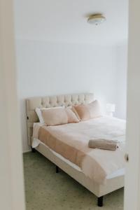 a bedroom with a large white bed with pink pillows at Carthage Terrace in Tamworth