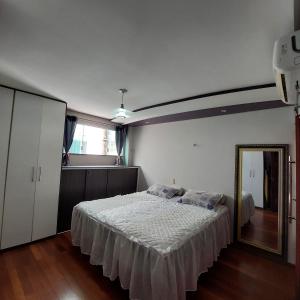 a bedroom with a large bed and a mirror at Cobertura COP30 in Belém +10 photos