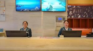 two women sitting at a table with their laptops at City Comfort Inn Lichuan Railway Station Jimi Home in Datang