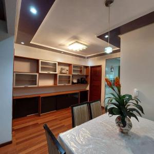 a dining room with a table and a vase of flowers at Cobertura COP30 in Belém