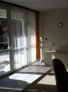 ein Wohnzimmer mit einer Glasschiebetür zu einer Terrasse in der Unterkunft Sirály Apartman in Balatonfůzfő