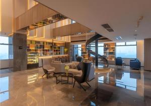 a lobby with couches and chairs and a staircase at Echarm Hotel Nanning Wuxiang Headquarters Base in Nanning +43 photos