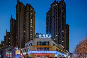 a building in a city with tall buildings at James Joyce Coffetel Luoyang Longmen High-speed Railway Station Baolong Plaza in Luoyang