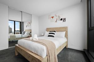 a bedroom with a large bed and a mirror at Home in the Sky 2BR Apt with City and River View in Melbourne +18 photos