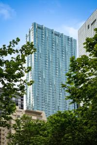 a tall glass building with trees in front of it at Home in the Sky 2BR Apt with City and River View in Melbourne