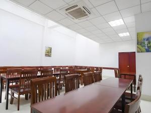 an empty classroom with wooden tables and chairs at VX Hotel Xiamen Siming District Xiamen University Huandao Road in Xiamen