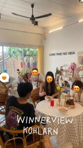 a group of dolls sitting at a table in a room at winnerview ll Resort Kohlarn in Ko Larn