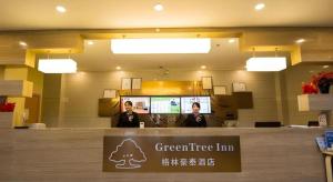 deux femmes debout derrière un comptoir dans un magasin dans l'établissement Green Tree Inn Tibet Lhasa Zhaji Temple, à Lhasa