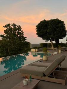 a swimming pool with a lounge chair and a table at KW 2 Villa in Ban Bang Po