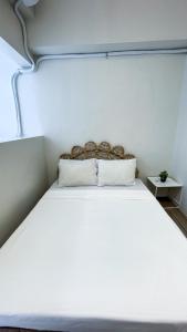 a large white bed in a room with at WV 30 Bright 2BR Escape in Sampong