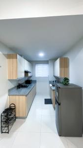 a kitchen with wooden cabinets and a stainless steel refrigerator at WV 30 Bright 2BR Escape in Sampong