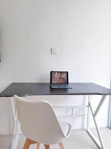 a black desk with a white chair and a box on it at Yan Loft in Uluwatu