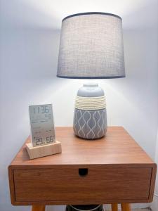 a lamp sitting on top of a table with a clock at Yan Loft in Uluwatu