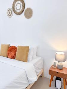 a white bedroom with a bed and a table at Yan Loft in Uluwatu