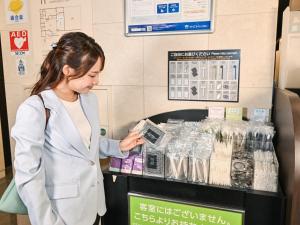 a woman standing in front of a cash register at Sanco Inn Nagoya Fushimi in Nagoya
