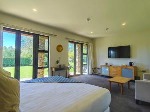 a bedroom with a large bed and a television at Lime Tree Lodge in Wanaka