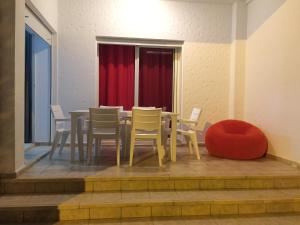 アシラにあるAssilah Marina golfのダイニングルーム(テーブル、椅子、赤いカーテン付) +4枚の写真