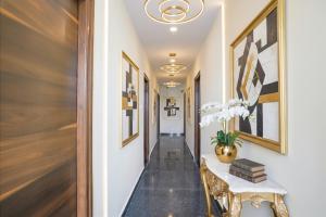 ハイデラバードにあるFabHotel Air Live - Nr Ameerpet metro stationのコンソールテーブルと壁に絵が飾られた廊下