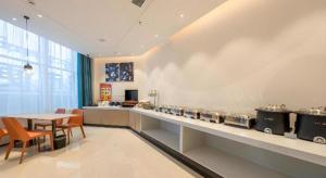 a kitchen with a table and a counter with pots and pans at City Comfort Inn Shannan Passenger Terminal in Nedong