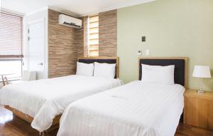 - 2 lits installés l'un à côté de l'autre dans une chambre dans l'établissement Good Morning Residence Hue, à Daejeon